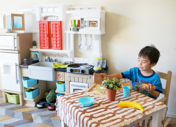 pre-schooler-plays-with-pretend-kitchen