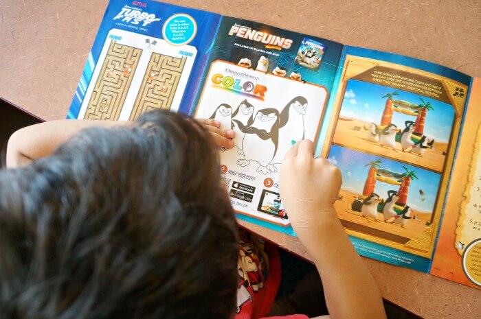 Boy coloring Denny's kids menu activity book
