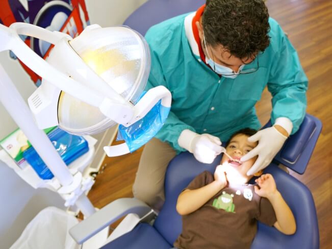 Colgate dentist checking child's teeth