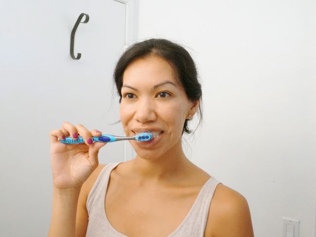 Brushing teeth with Colgate Total Daily Repair