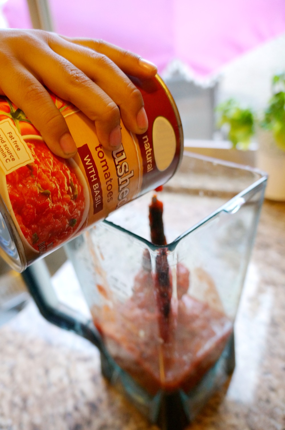 Adding crushed tomatoes with basil