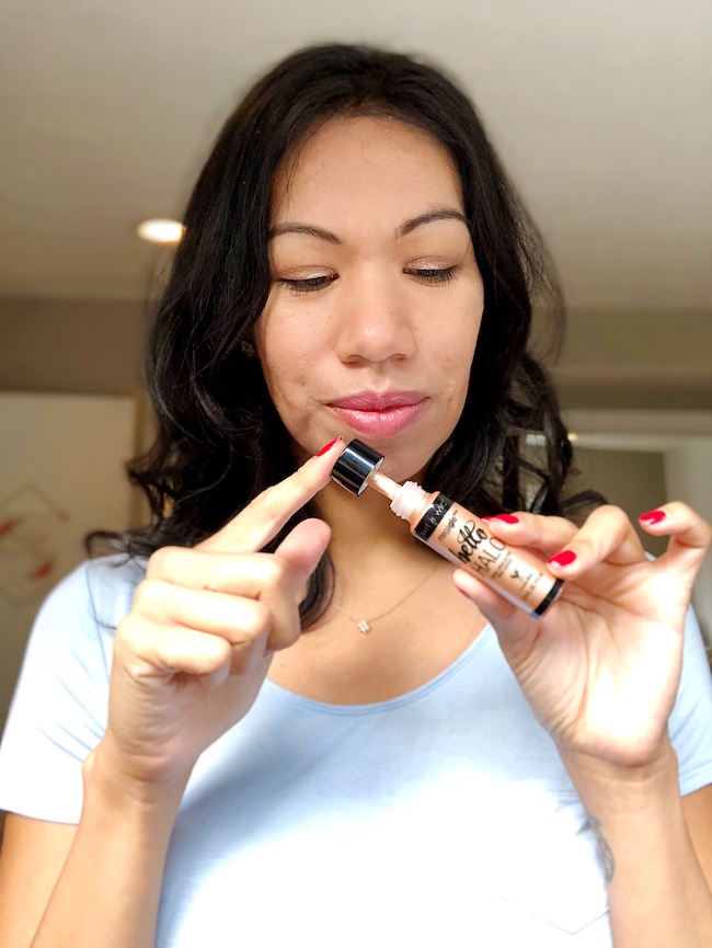 Latina lifestyle blogger showing a bottle of liquid highlighter
