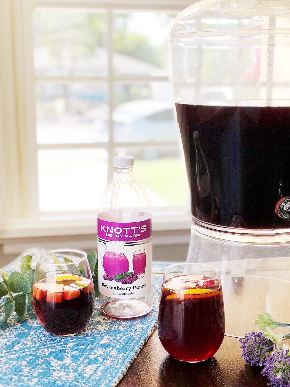two cups of boysenberry sangria on a blue placemat