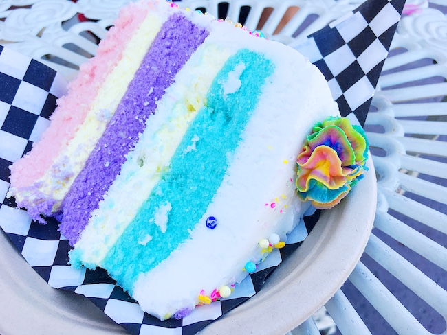 Unicorn cake on black and white checked paper.   #unicornfoods #unicornbark #unicorns #partyfood #unicornparty #unicorntreats #unicornpartytreats  livingmividaloca.com